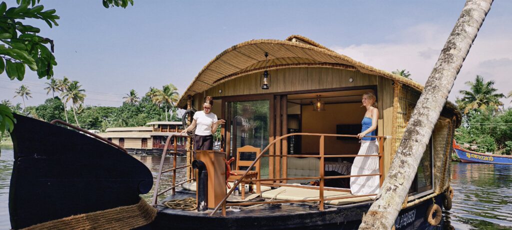 Foreign guests relaxing on houseboat deck in Alleppey backwaters